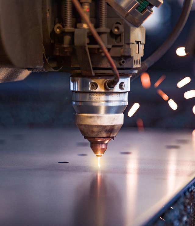 Close up of a laser cutting machine starting to pierce a metal plate