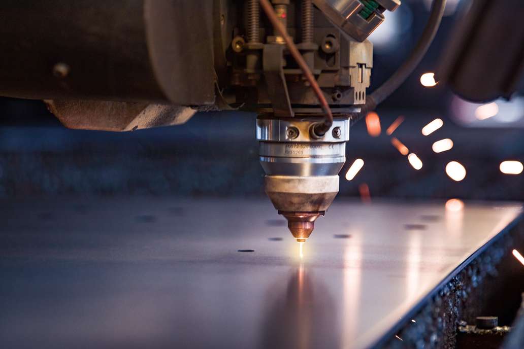 Close up of a laser cutting machine starting to pierce a metal plate